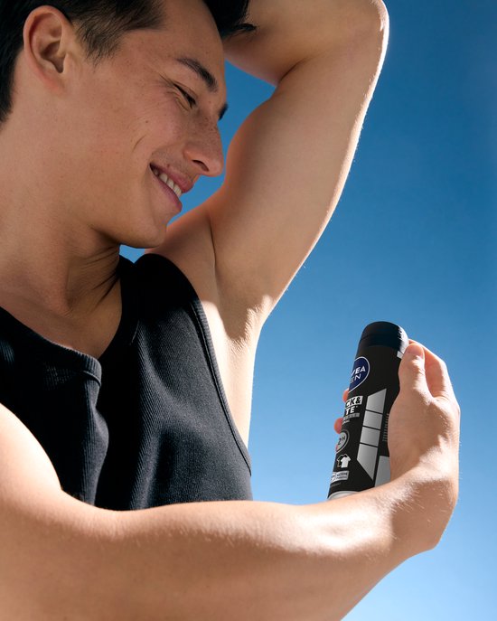 Man met tanktop die NIVEA MEN Black & White Invisible Original deodorant spuitbus onder zijn arm houdt.