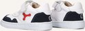 Twee witte leren sneakers met donkerblauwe suède accenten. Veters, klittenband en rode details. Nummer 21 op zool.