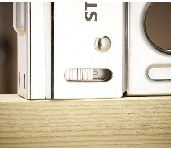 Close-up van Stanley tacker met metalen behuizing, schuifregelaar en zichtbare klinknagels op houten plank.