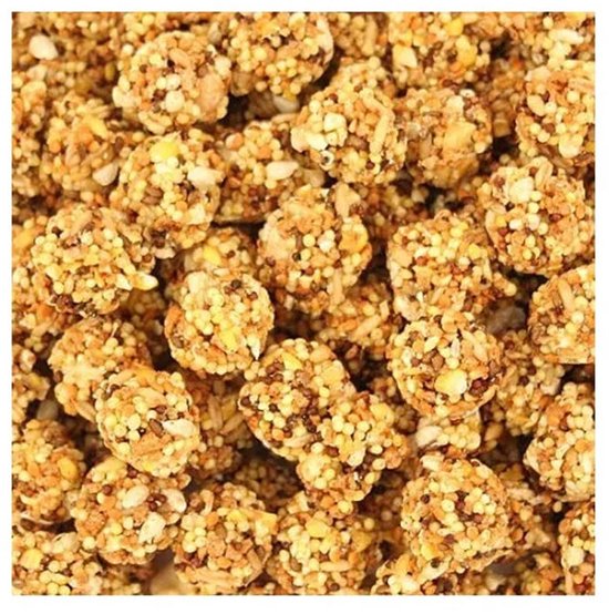 Close-up van Nutri-Berries, ronde pellets met verschillende granen en zaden in geel, bruin en wit.