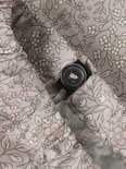 Roze regenbroek met een witte en lichtroze bloemenprint en een knoopsluiting.
