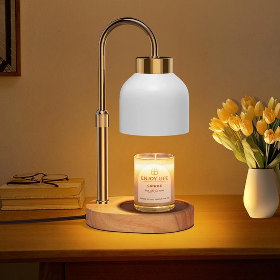 Gouden kaarswarmerlamp met witte kap en houten voet, smelt een geurkaars. Naast een vaas tulpen.