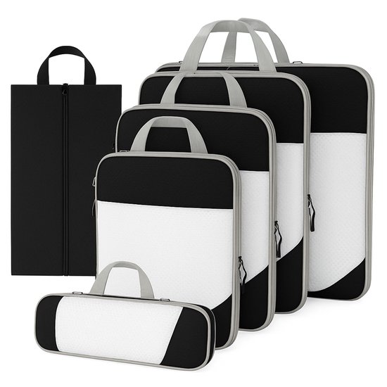 Een set van vijf zwarte en witte packing cubes van verschillende afmetingen, met grijze handvatten en ritsen. Een zwarte schoenenzak staat vooraan.