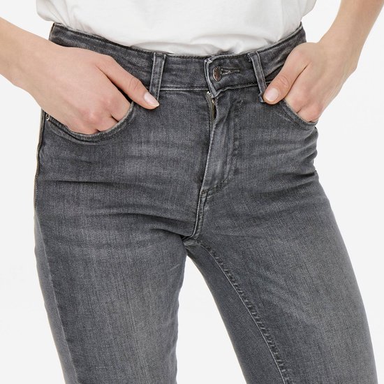 Close-up van het voorpand van een lichtgrijze denim jeans met handen in de zakken.
