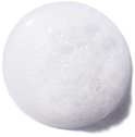 Une goutte de substance blanche moussante sur fond blanc.