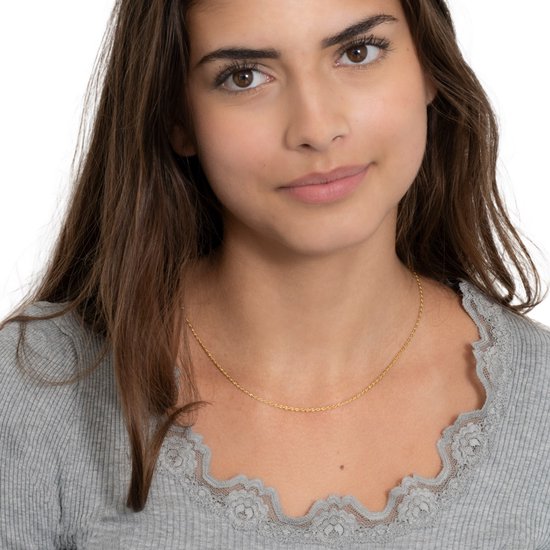 Model draagt een dunne gouden touwketting.