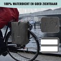 Zwarte, waterdichte Vebics fietstas rugzak op fiets, met reflecterende strepen, in regen.