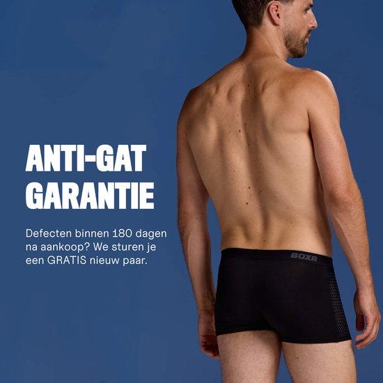 Man in zwarte BOXR boxershort, met mesh-detail op de zijkant. Tekst "ANTI-GAT GARANTIE" en uitleg over gratis vervanging.