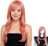 Een vrouw met een lichtroze pruik met pony en golvend haar, lachend. Naast haar een mannequin met dezelfde pruik.