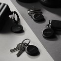 Vier zwarte Chipolo LOOP trackers met sleutels en een tas