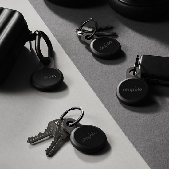 Vier zwarte Chipolo LOOP trackers met sleutels en een tas
