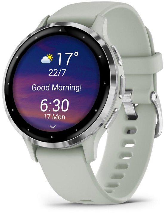 Garmin Venu 3s smartwatch met een zachtgroene band en een zilverkleurig metalen frame. Het scherm toont "Good Morning!" met de tijd, datum en temperatuur.