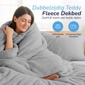 Vrouw gehuld in een zachte, grijze teddy fleece dekbedovertrek. Dubbelzijdig, ademende stof.