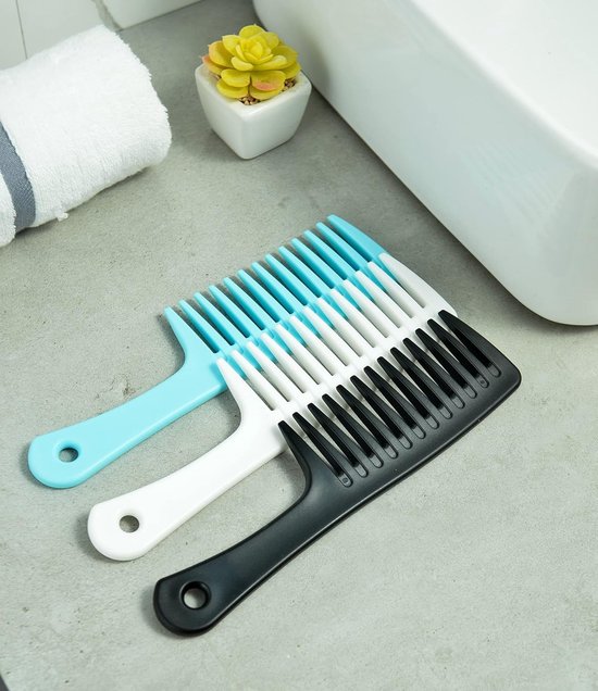 Drie kammen in blauw, wit en zwart met extra brede tanden, liggend op een aanrecht.