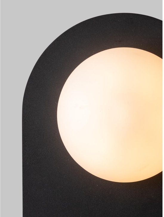 Zwarte boogvormige wandlamp met ronde, melkachtige glazen kap.