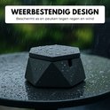 Zwarte, zeshoekige asbak met deksel, nat van de regen op een tuintafel. Tekst: WEERBESTENDIG DESIGN.