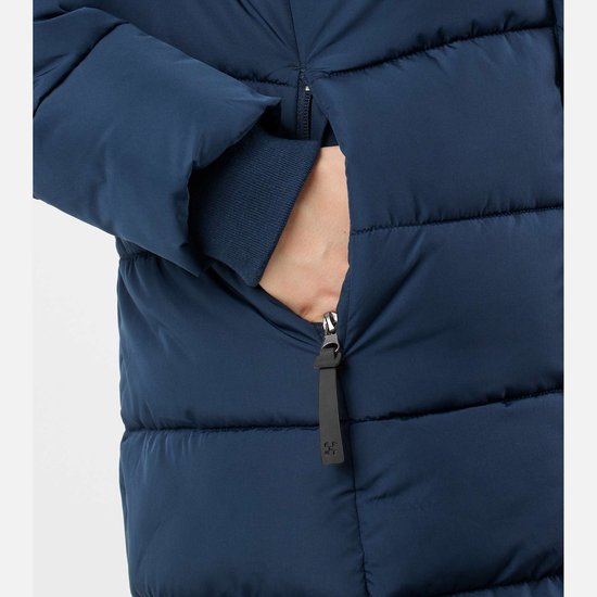 Close-up van een hand die een rits van een zak in een donkerblauwe, gewatteerde winterjas sluit.