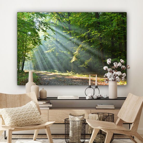 Een bosweg met zonlicht dat door de bomen valt, hangt boven een dressoir met vazen en kandelaars.