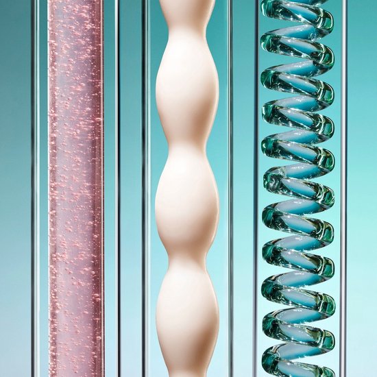 Close-up van verticale transparante buizen met roze bubbels, een crèmekleurig object en blauwe spiraalvormige vloeistof.