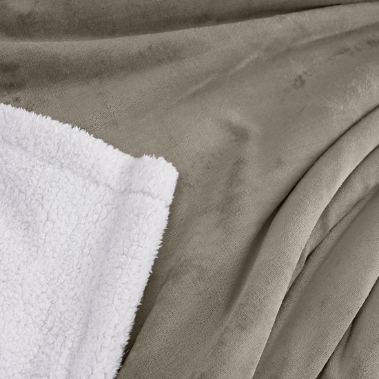 Close-up van de taupe fleece stof en de witte sherpavoring van een plaid.
