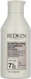 Flacon de shampoing blanc Redken avec étiquette rose indiquant 'acidic bonding concentrate shampoo'.