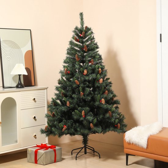 Kunstkerstboom van 180 cm versierd met dennenappels en bessen, opgesteld in een woonkamer bij een geschenkdoos.