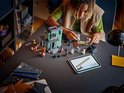 Un garçon construit un manoir hanté vert avec des figurines LEGO et une tablette d'instructions.