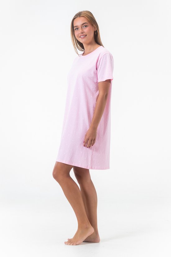 Model in een roze nachthemd met korte mouwen en all-over witte hartjesprint.
