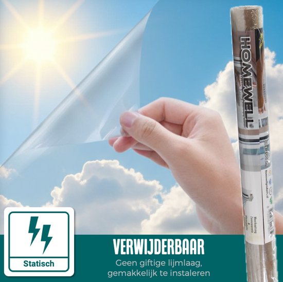 Hand pelt statische raamfolie van de rol met een blauwe lucht op de achtergrond.