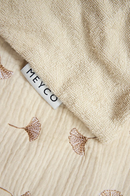 Witte hydrofiele deken met bruine ginkgo bladeren print, label 'Meyco'.