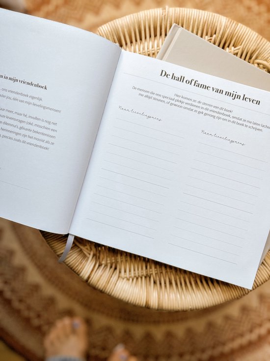 Openstaand vriendenboek op een rieten stoel. Pagina's met de tekst 'De hall of fame van mijn leven' en ruimte voor namen.