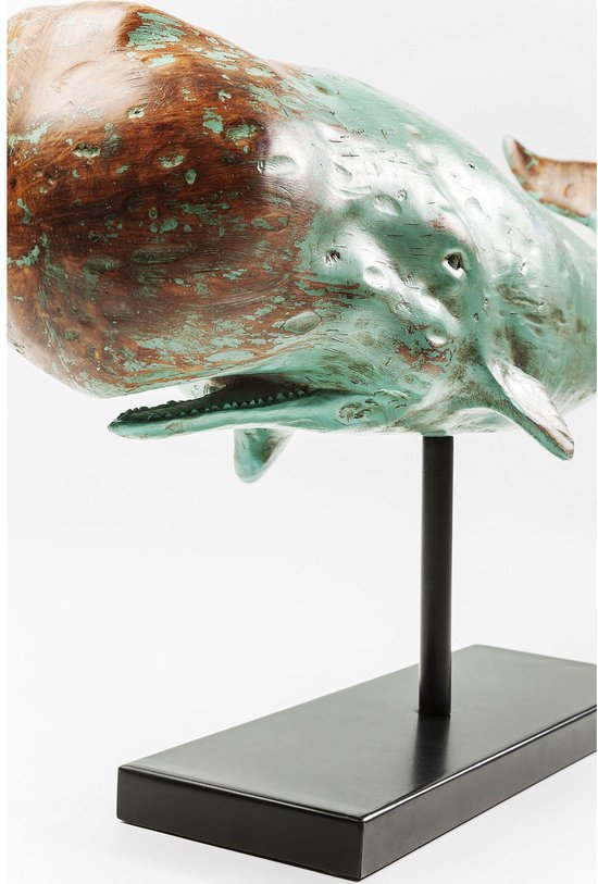 Detail van een verweerd turquoise en bruin houten walvisbeeld, met open mond, op een zwarte standaard.