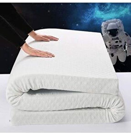 Un surmatelas blanc enroulé, avec des mains dessus, sur fond d'astronaute et de ciel étoilé.