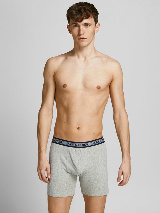 Man draagt een lichtgrijze Jack & Jones boxer met blauw logo-elastiek.