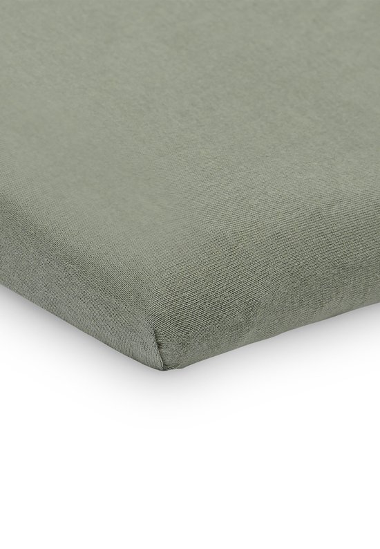 Een baby hoeslaken in de kleur ash green, close-up van de hoek met elastische rand.