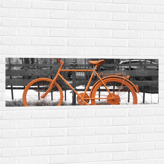 WallClassics - Muursticker - Oranje Fiets tegen Zwart Witte Achtergrond - 120x40 cm Foto op Muursticker