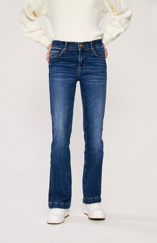 Model draagt een donkerblauwe flared jeans, de voorkant van LTB.