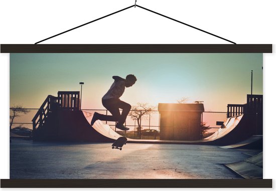 Posterhanger incl. Poster - Schoolplaat - Een jongen doet een stunt met zijn skateboard tijdens de zonsondergang - 90x45 cm - Zwarte latten