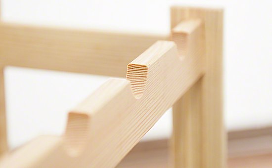 Detail van de inkepingen van een houten wijnrek met zichtbare houtnerven.