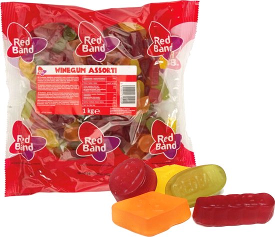 Een rode zak met Red Band Winegum Assorti, 1kg. Op de voorgrond liggen vier winegums: rood, geel, oranje en groen.