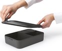 Handen plaatsen deksel op een lege donkergrijze bento lunchbox met scheidingswanden.