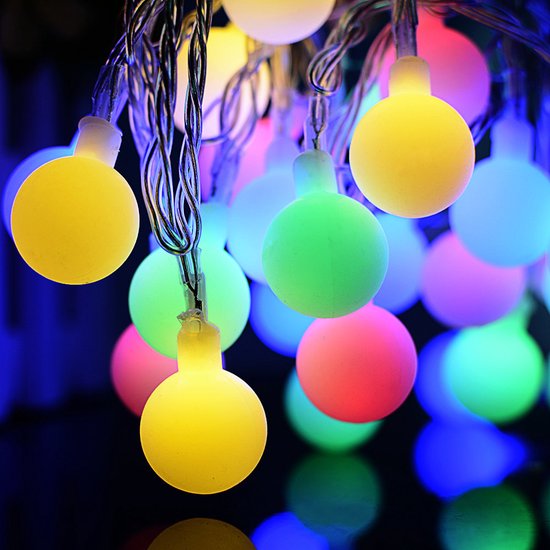 Guirlande de lumières colorées en grappes: jaune, vert, rose, violet et bleu, sur fond sombre.