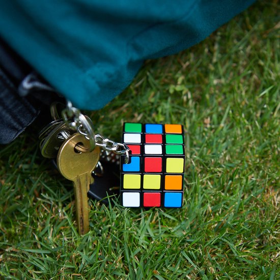 Rubik's Cube sleutelhanger naast een sleutelbos op gras.