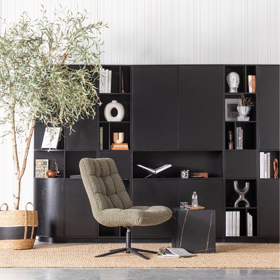 Zwarte wandkast met open vakken en gesloten deuren, gevuld met boeken, vazen en decoraties, met stoel en bijzettafel.