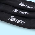 Close-up van de tekst 'Heavenly' op zwarte sokken.