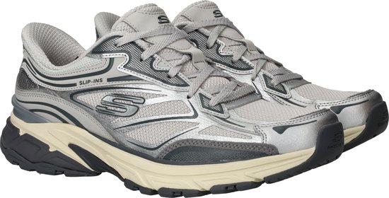 Paar zilverkleurige Skechers Stamina Sport Slip-Ins sneakers op een witte achtergrond.