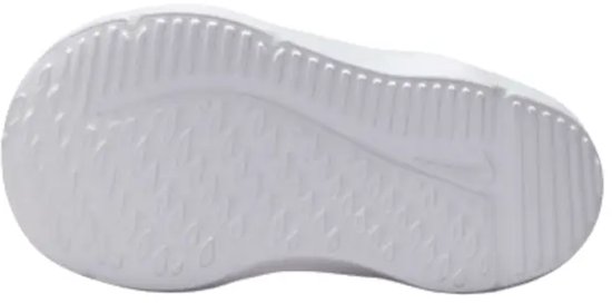 Onderkant van een witte sneaker met zoolprofiel en Nike logo.