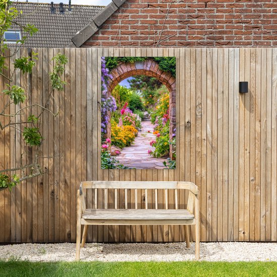 Tuinposter met een stenen boog en bloemen, hangend aan een houten schutting, met een houten bankje ervoor.