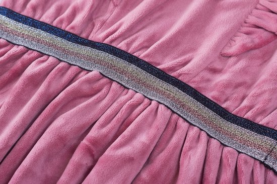 Detail van een roze fluwelen jurk, met ruches en een glitter tailleband.