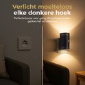 Zwarte stekkerlamp met warm licht verlicht een donkere gang of overloop, zonder schakelaars.